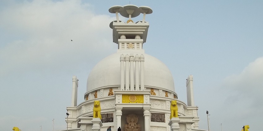 Sanchi Stupa at Dhauli Hills with traditional white Buddhist architecture and people visiting.