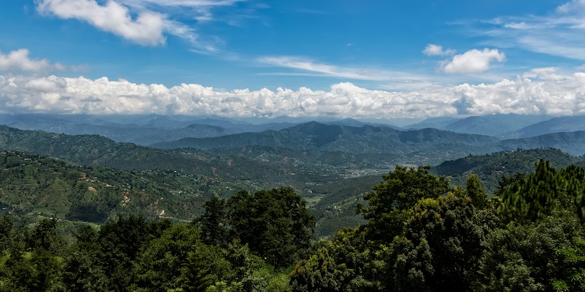 Scenic view of Dhulikhel with lush green hills, clouds, and serene natural landscape.