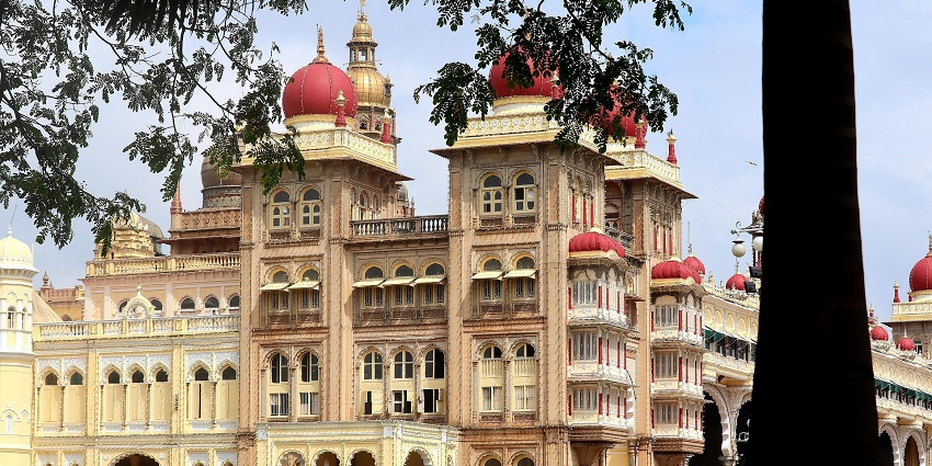 Elegant red-domed building with arched windows and towers, viewed from the lawn.
