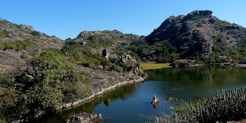 Scenic view of Mount Abu, featuring a calm lake and its surrounding mountain landscape.