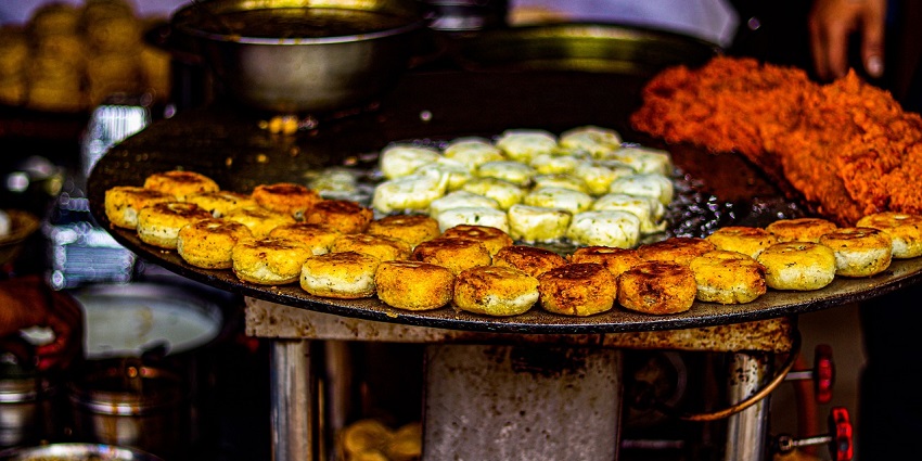 Close-up of popular Varanasi street food dishes arranged on a rustic surface.