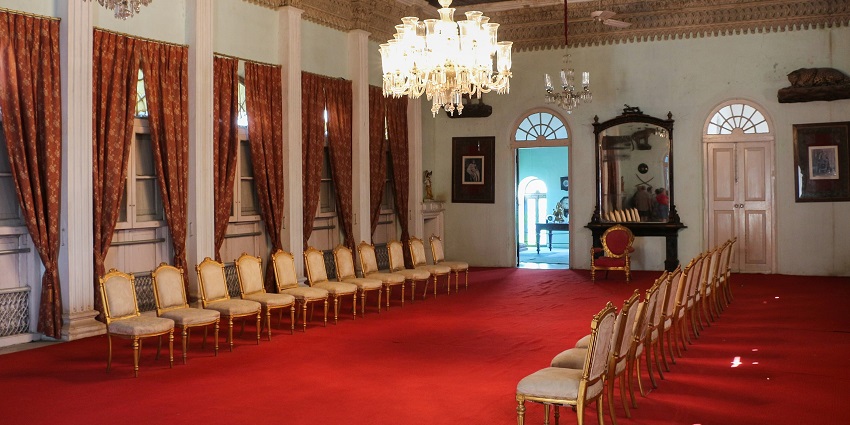 Royal chairs inside Gondal Palace, showcasing heritage decor, one of the places to visit near Gadhada.
