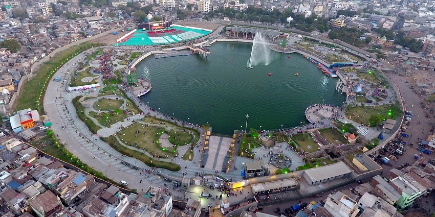 Aerial view of a circular city lake with fountains, gardens, and walking paths, one of the places to visit near Surat for 1 day.