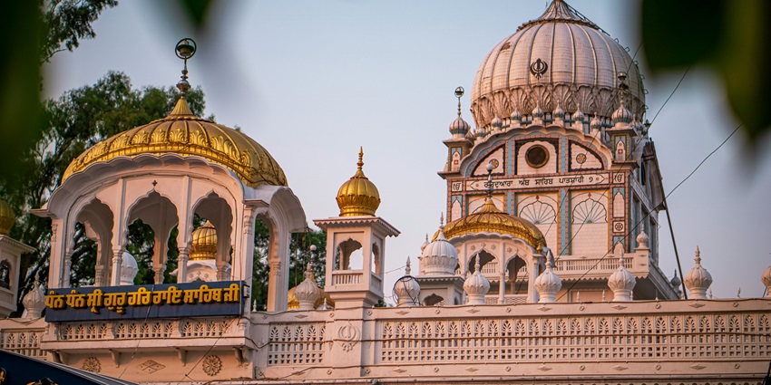 White dome of Gurdwara Haji Rattan against a clear blue sky in a serene setting.