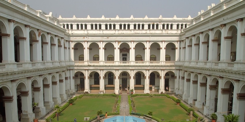 Courtyard of the indian museum with a fountain in the middle of the courtyard and people visiting.
