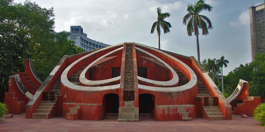 Red astronomical structure with curved staircases and circular design, one of the places to visit near Janpath Market.
