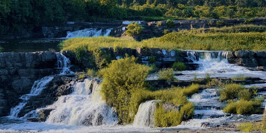 Stunning waterfall cascading, surrounded by dense forest vegetation.