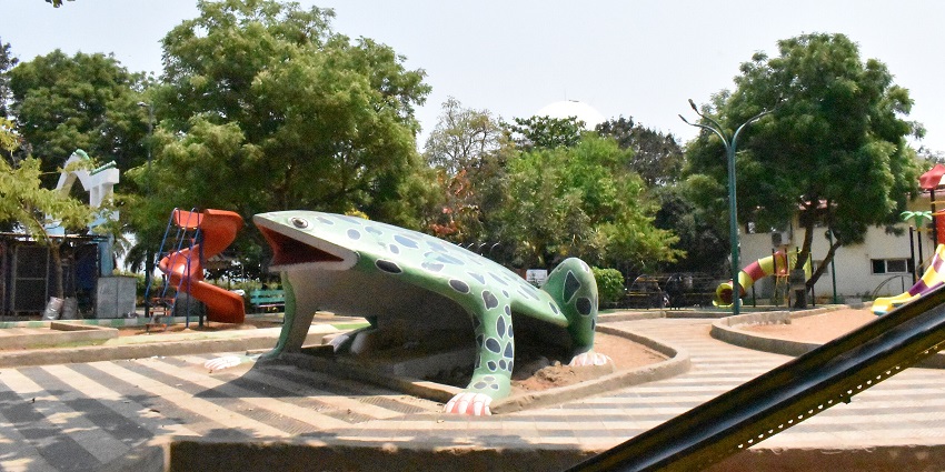 Curving railway track through garden pathway lined with large trees and palm foliage, one of the best places to visit near Vizag for 3 days