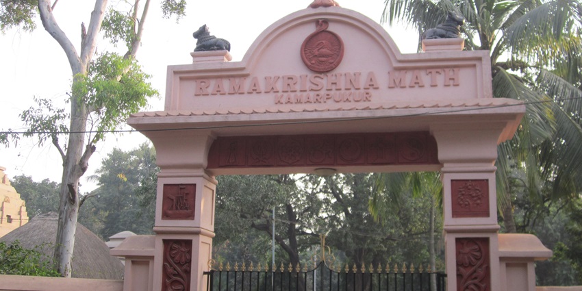 A crowd gathered at a large arched gate with ornate carvings and decorative stone statues