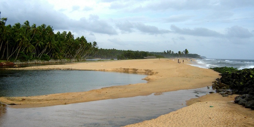 Kappil lake and beach in Kerala with sandy shores and palm trees, beautiful places to visit near Attingal.
