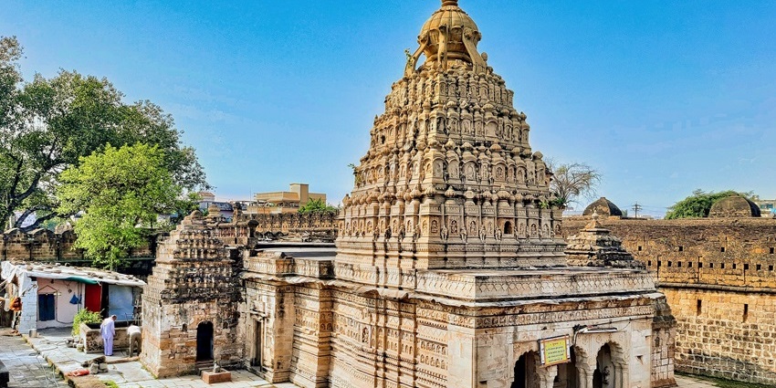 Katraj Jain Temple with intricate carvings and peaceful surroundings on a clear sunny day.