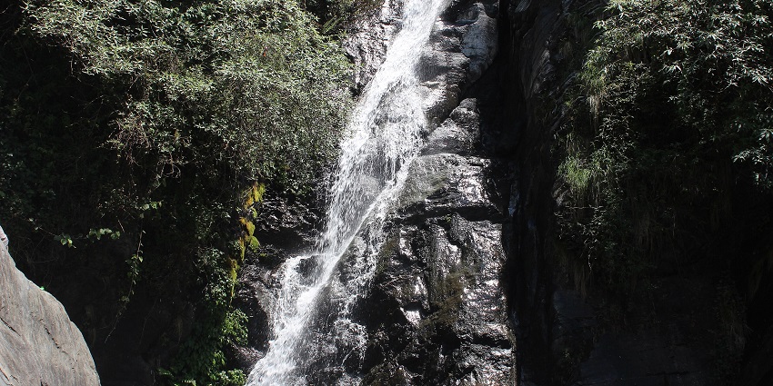 Narrow waterfall cascading down dark, one of the best places to visit near Chakrata.