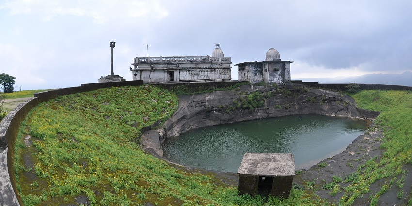 Structure of the Jain Temple on top of the Kundadri Hill, with a green pond next to it.
