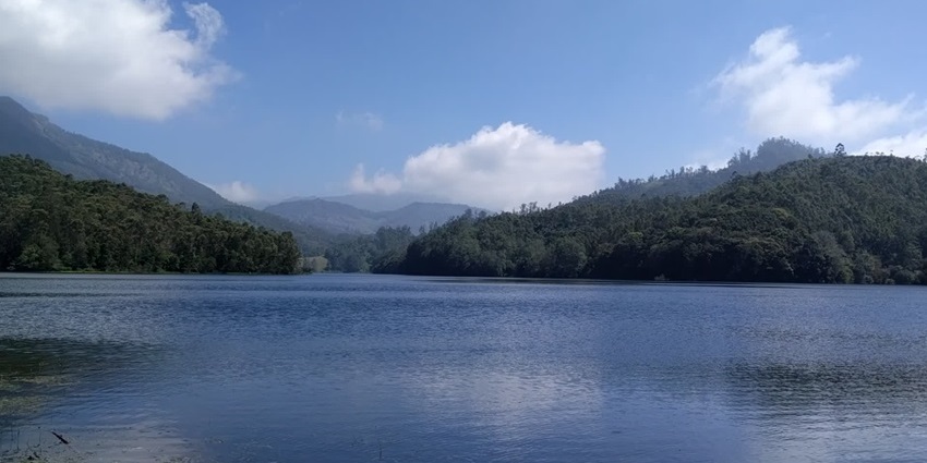 Kundala lake in Kerala with a large calm water body, distant greenery, and mountains.