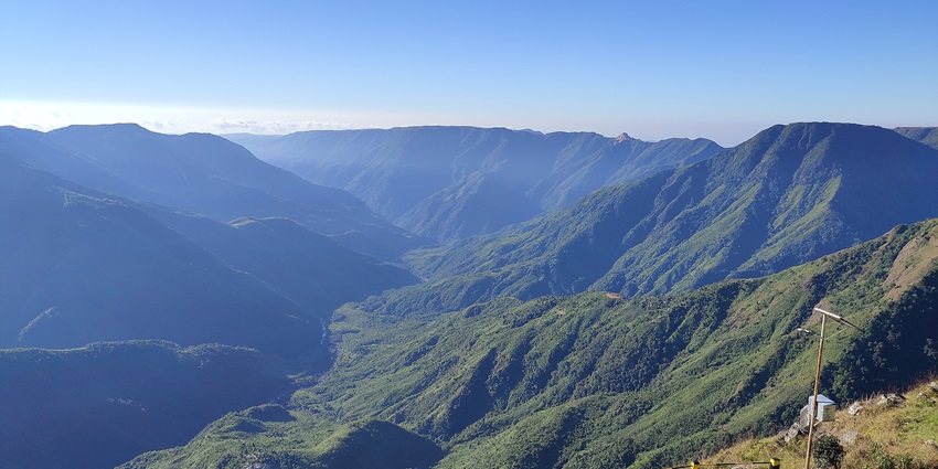Laitlum Canyons with stone pathway, yellow black railings and green mountains around.
