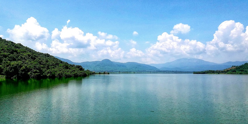 Scenic view of Loktak Lake with calm waters and distant hills under a clear sky.
