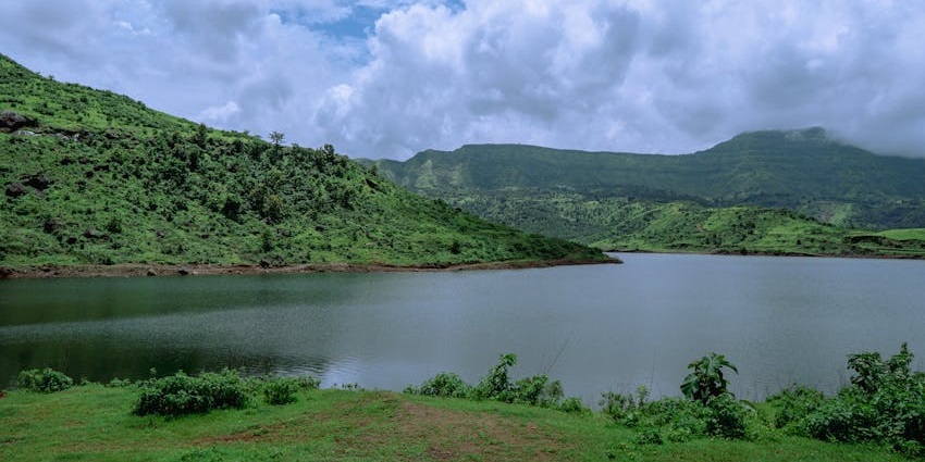 Peaceful view of Lonavala Lake surrounded by greenery and hills.