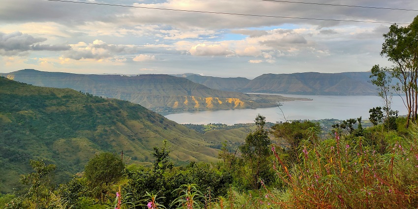 Panoramic view of lush green hills and a winding river in Mahabaleshwar.