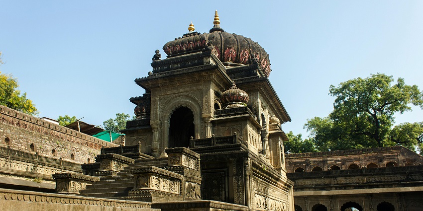 An ornate temple with intricate carvings and steep steps in Maheshwar, Madhya Pradesh.
