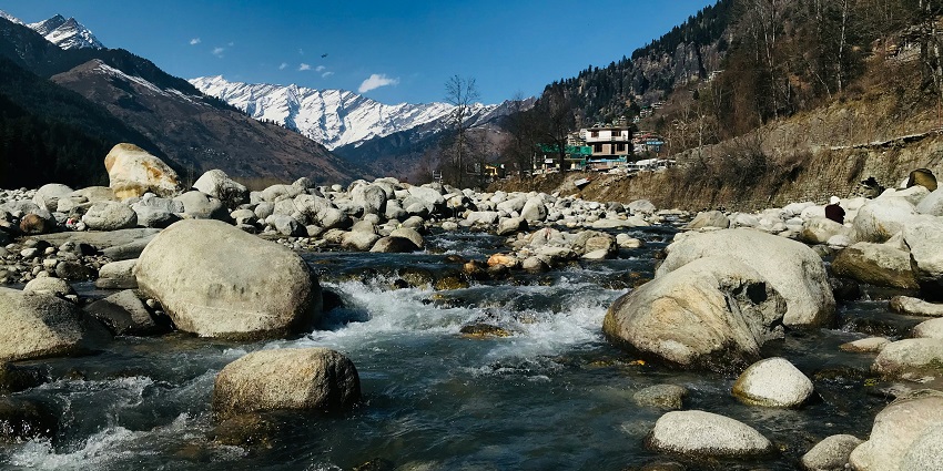 River flowing over rocks in Manali, one of the cold places to visit near Delhi.
