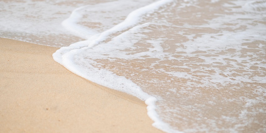 Scenic view of Mandarmani Beach with waves crashing over the sandy shore.
