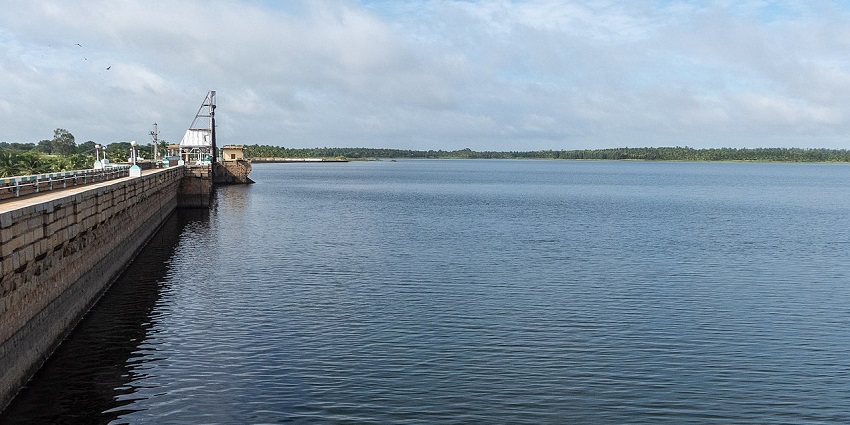 Markonahalli dam reservoir with a large calm water body, distant greenery, and unique lamps.