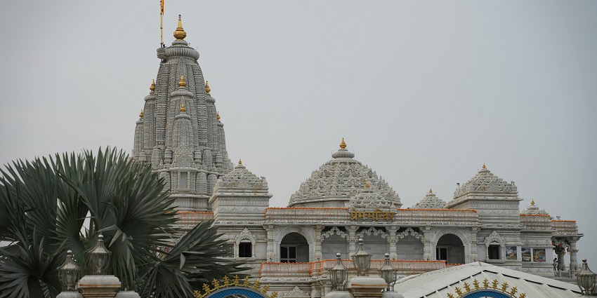 Prem Mandir temple with detailed carvings and colorful decorations during the day.