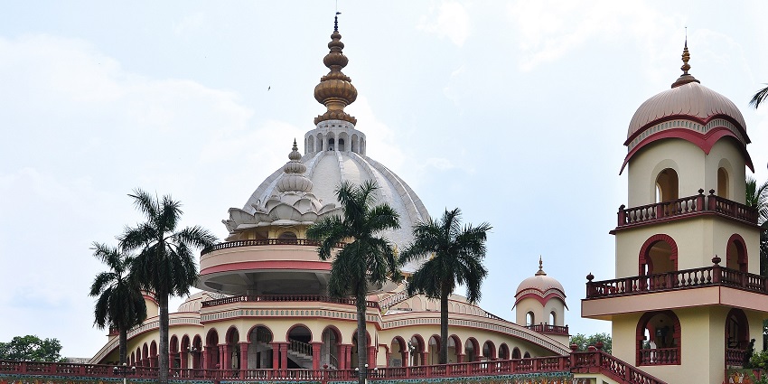 Samadhi Mandir in Mayapur with cool poles and winged trees, standing up against the sky.