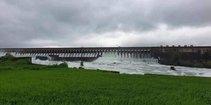Mukutmanipur Dam and Reservoir with water flowing and surrounded by grennery.