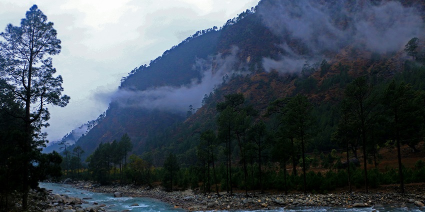 A calm river in Mussoorie flowing through lush green hills and peaceful surroundings.
