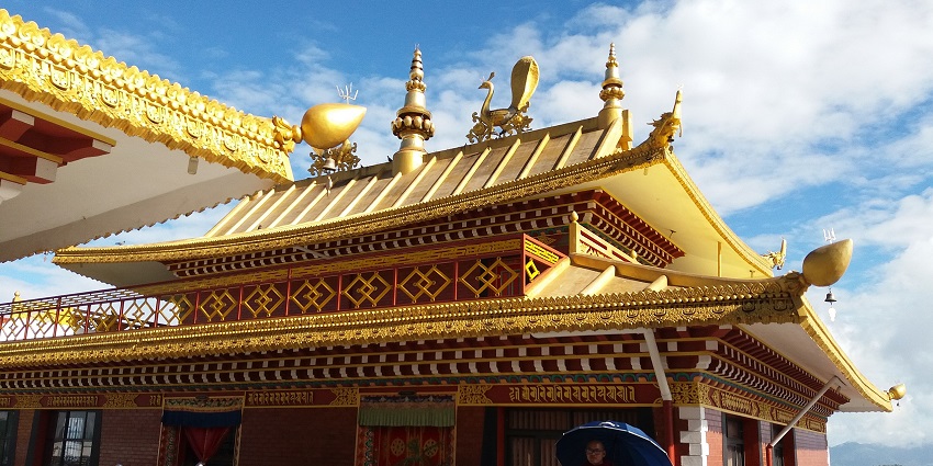 Main hall at Namobuddha with traditional architectural design and golden rooftop decoration.