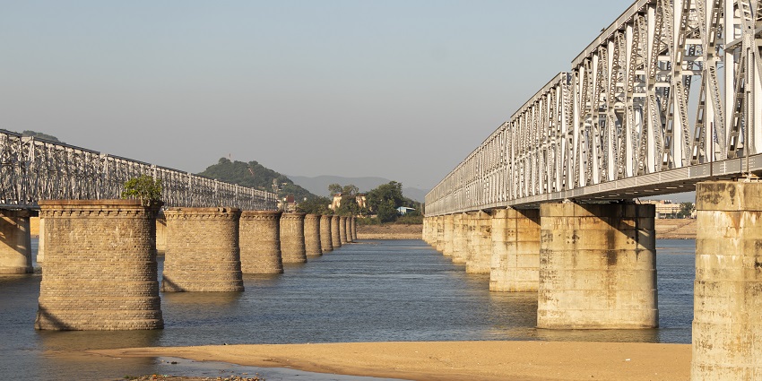 Two parallel railway bridges run across the Narayanapura Dam.
