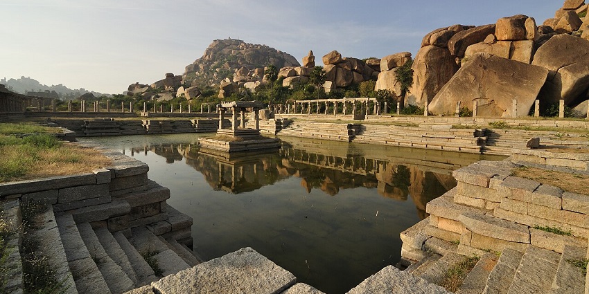Navinakere water tank is surrounded by rocks and steps, a peaceful historic spot near Gubbi.