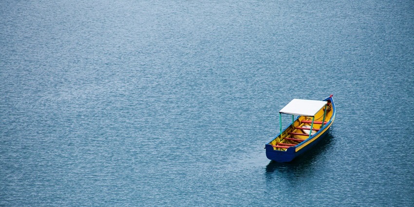 Brahmaputra River with a boat sailing calmly across the wide flowing waters.
