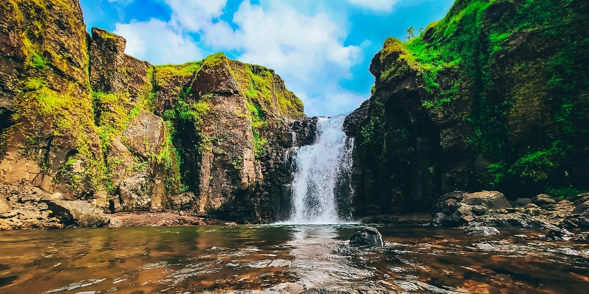 Cascading Pandavkada Waterfalls are surrounded by lush greenery and scenic natural beauty.
