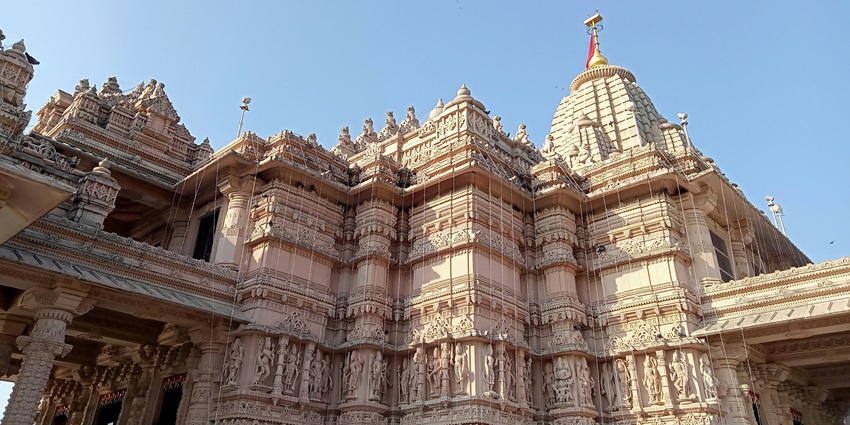 Patal Bhuvaneshwar Cave Temple with an old architectural temple under a clear sky.