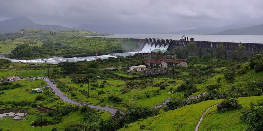 Scenic view of Pawna Lake, one of the top places to visit near Khandala, surrounded by green hills.
