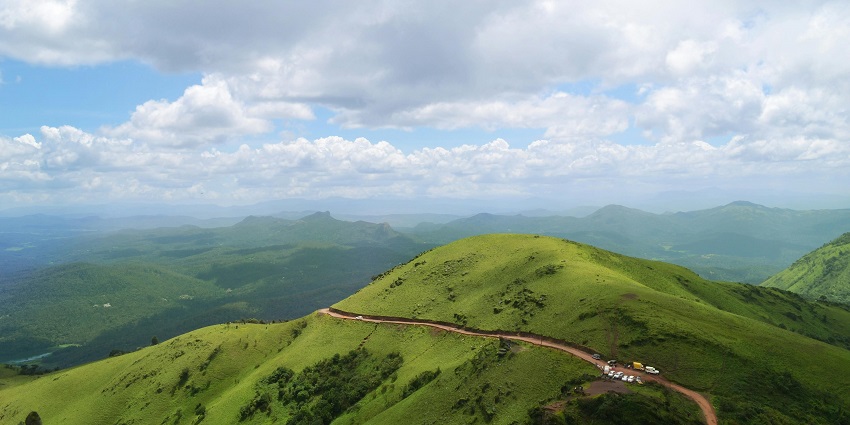 Green mountains beneath a cloudy sky in Chikmagalur highlighting what is Chikmagalur famous for.