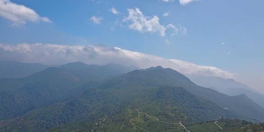 Ponmudi hills in Kerala showing winding roads, scattered houses, and lush greenery.