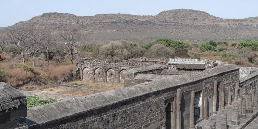 Majestic view of Prabalgad Fort surrounded by lush greenery and rocky terrain.