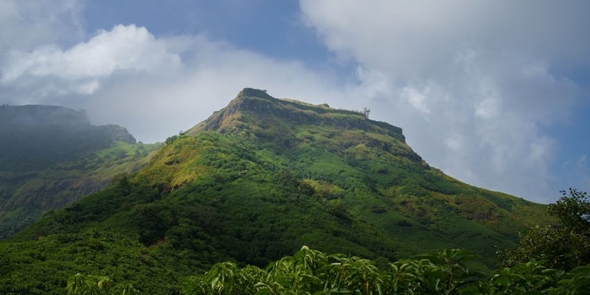 Purandar Fort hilltop view with open landscape and clear skies in the background.