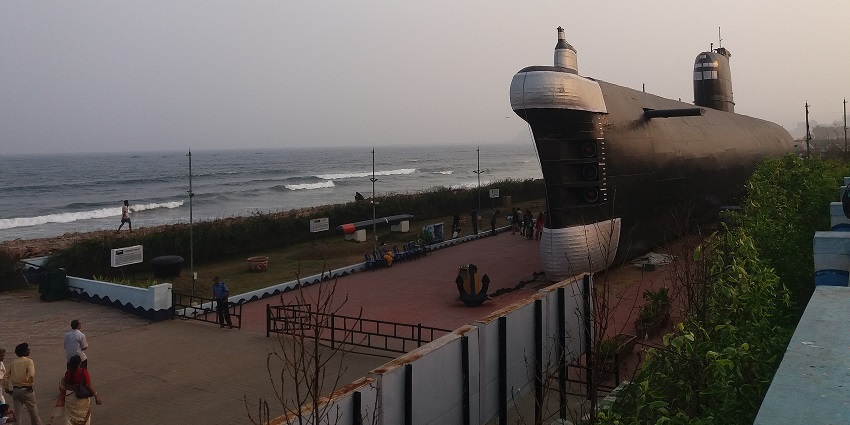 A retired navy submarine was placed on the beachfront grassy lawn in a sunny, cloudy sky, one of the best places to visit near Vizag for 3 days.