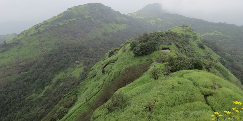 Rajmachi Fort is surrounded by lush greenery and scenic mountain views.