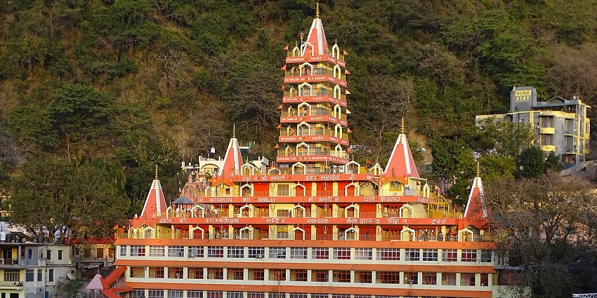 Morning sunlight glows the red colour of the Trayambakeshwar Temple along the Ganga River, one of the places to visit near Delhi for 3 days.