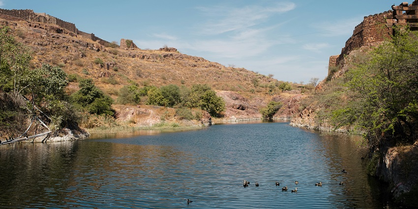 A wide view of Sambhar Salt Lake with calm waters under the clear sky.