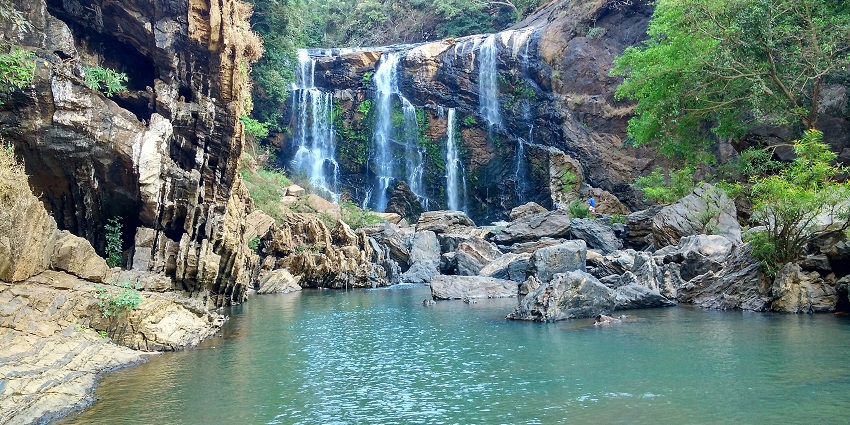 Cascades of water falling from the weathered rocks at Sathodi Falls, one of the best places to visit near Dandeli.