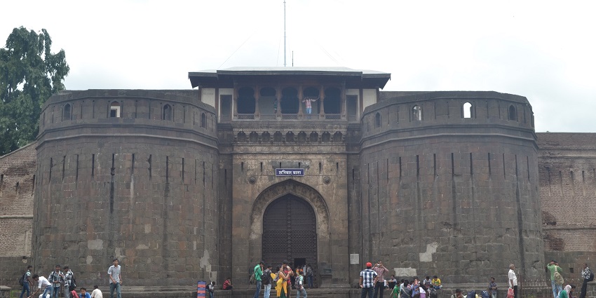 Historic stone entrance known as Shaniwar Wada in Pune with a group of tourists, one of the best places to visit near FC Road.