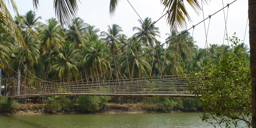 A wide view of a hanging bridge, or Shivapura Hanging Bridge, with a calm river flowing underneath it.