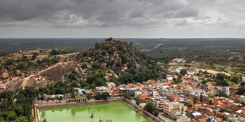 Aerial view of Shravanabelagola with green water body and hills, one of the places to visit near Adichunchanagiri.