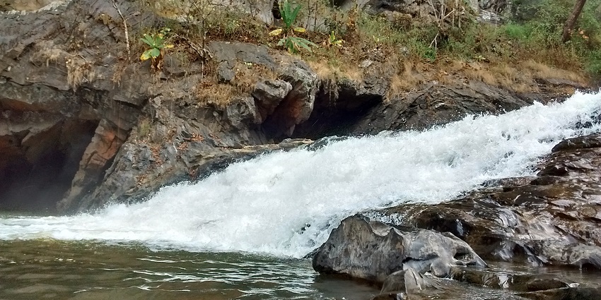 Water becomes foamy as it runs down a slope at Syntheri Rocks, one of the best places to visit near Dandeli.